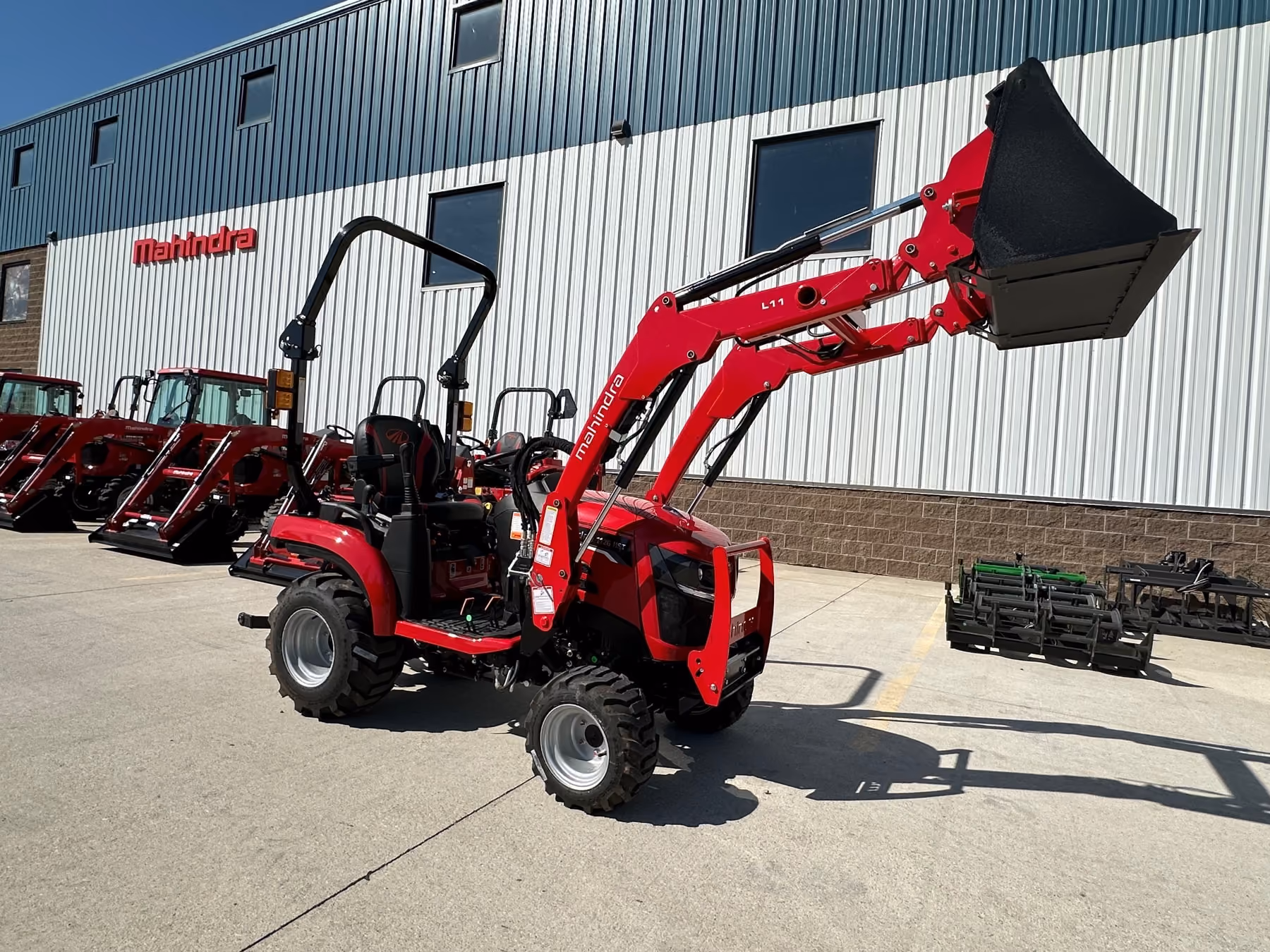Mahindra 1100 series sub-compact tractor with a loader outside the dealership